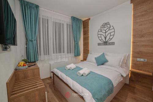 a bedroom with a bed with towels on it at Хотел Терра Роза in Karlovo