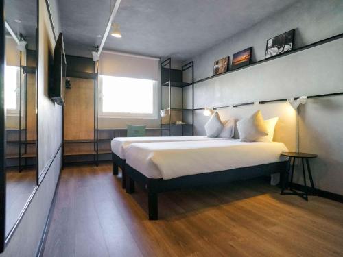 - une chambre avec un grand lit blanc dans l'établissement Ibis Montmelo Granollers, à Granollers