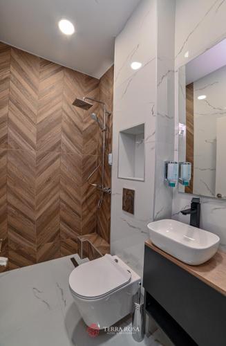 a bathroom with a white toilet and a sink at Хотел Терра Роза in Karlovo