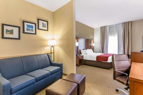 BurlingtonにあるComfort Suites South Point - Huntingtonのソファとベッド付きのホテルルーム