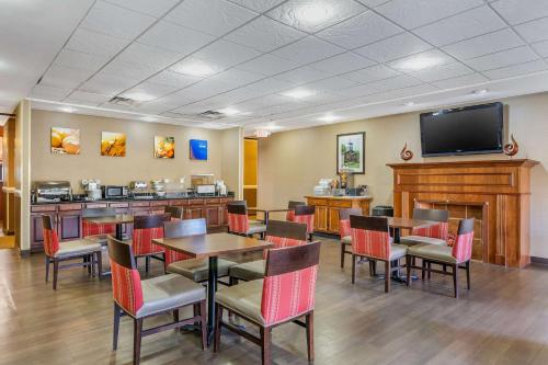 a restaurant with tables and chairs and a flat screen tv at Comfort Suites South Point - Huntington in Burlington