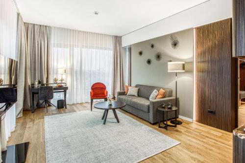 ein Wohnzimmer mit einem Sofa und einem Tisch in der Unterkunft Parkhotel Heilbronn in Heilbronn