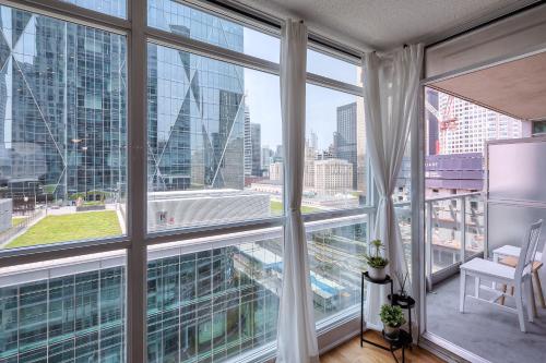 an apartment with large windows and a view of a city at RivetStays - The Yonge in Toronto