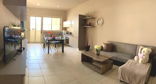 sala de estar y cocina con sofá y mesa en Sliema Aqualuna Premium Apartment en Sliema