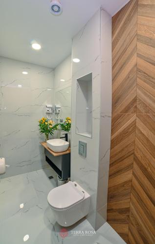 a bathroom with a white toilet and a sink at Хотел Терра Роза in Karlovo