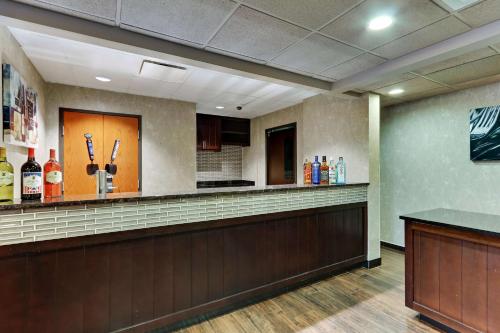 a lobby with a bar with bottles of alcohol at Drury Plaza Hotel San Antonio Airport in San Antonio