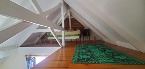 an attic room with a green rug on the floor at Seachange Lodge in Port Vila