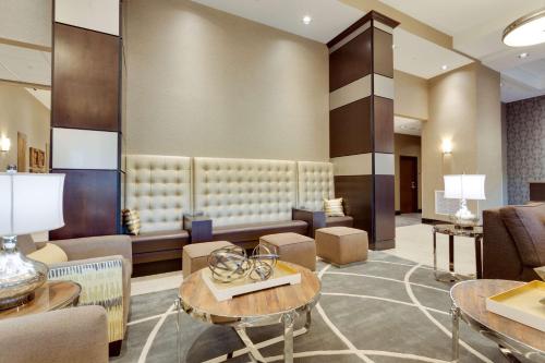a lobby with a waiting room with tables and chairs at Drury Inn & Suites Dallas Frisco in Frisco