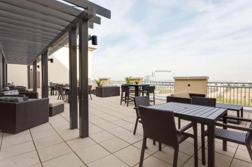 a patio with tables and chairs on a balcony at Drury Inn & Suites Dallas Frisco in Frisco