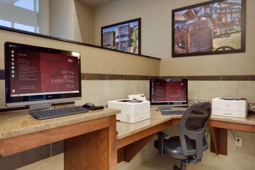 a office cubicle with two computers on a desk at Drury Inn & Suites Dallas Frisco in Frisco