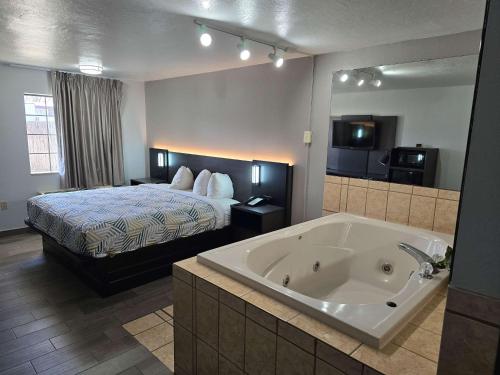a hotel room with a bed and a bath tub at Motel 6 Oklahoma City OK Frontier City in Edmond
