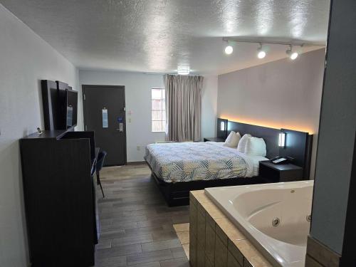 a hotel room with a bed and a bath tub at Motel 6 Oklahoma City OK Frontier City in Edmond