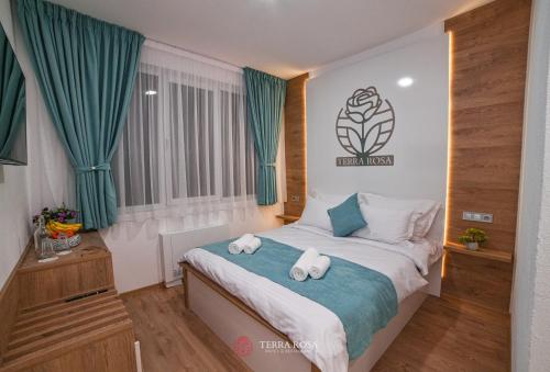 a bedroom with a bed with towels on it at Хотел Терра Роза in Karlovo