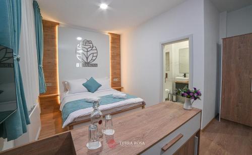 a small bedroom with a bed and a table at Хотел Терра Роза in Karlovo