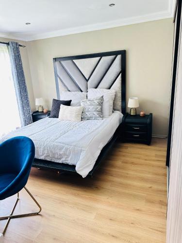 a bedroom with a large bed and a blue chair at Mayberry Heights in Alberton
