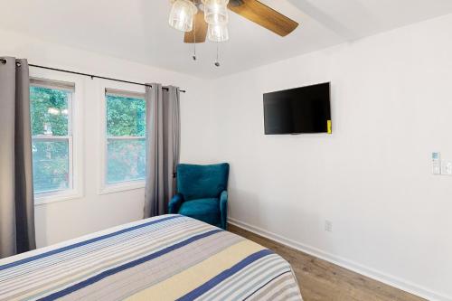 a bedroom with a bed and a blue chair at The Pool House in Charlotte