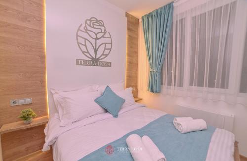 a bedroom with a bed with a sign on the wall at Хотел Терра Роза in Karlovo