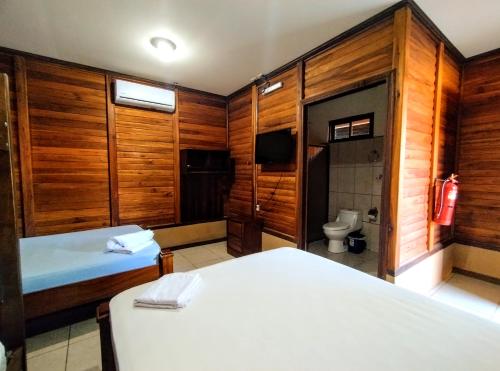 a room with two beds and a bathroom with a toilet at Cabinas Río Frío in San Rafael
