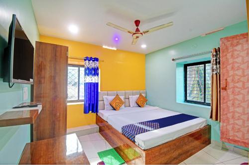 ein Schlafzimmer mit einem Bett und einem TV. in der Unterkunft SPOT ON Mahaveer Resort in Bhadrak