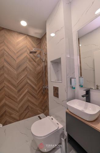 a white bathroom with a toilet and a sink at Хотел Терра Роза in Karlovo