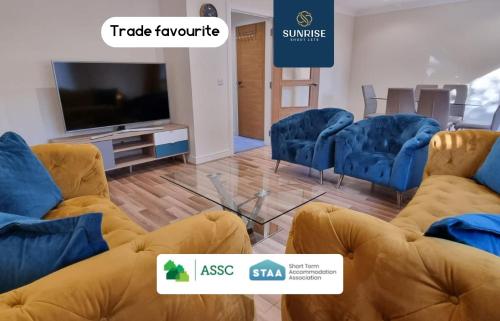 a waiting room with blue chairs and a tv at MUIRTON HOUSE - INVOICE and REDUCED PRICE only via SUNRISE SHORT LETS DUNDEE, 4 Bed House, 4 Car Driveway, 2 Bathrooms, Smart TVs in every room, Fully Equipped Kitchen, Large Dining and Living Space, Rear Garden, Free WiFi, Mid to Long Stay Rates in Dundee