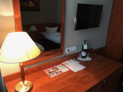 a table with a lamp and a bottle of wine on it at Hotel Astrid am Kurfürstendamm in Berlin