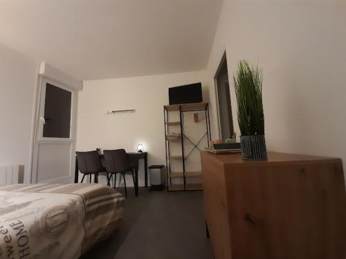 a bedroom with a bed and a table with a potted plant at Résidence du Léon in Landivisiau