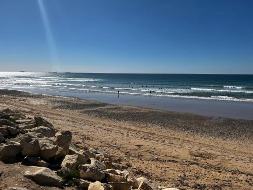a beach with a bunch of rocks and the ocean at The blue pearl-Sensational beach apartment in Aourir in Agadir