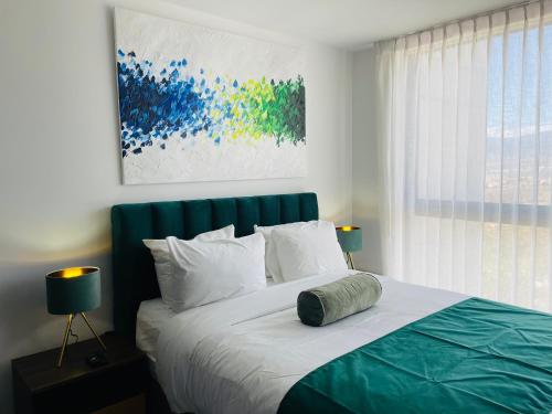 a bedroom with a large bed with a painting on the wall at SkyGarden Nunciatura Luxury Apartment in San José