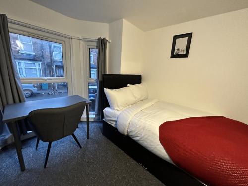 諾丁漢的住宿－Stay Sleep Rest - Gawthorne，一间卧室配有一张床、一张书桌和一个窗户。