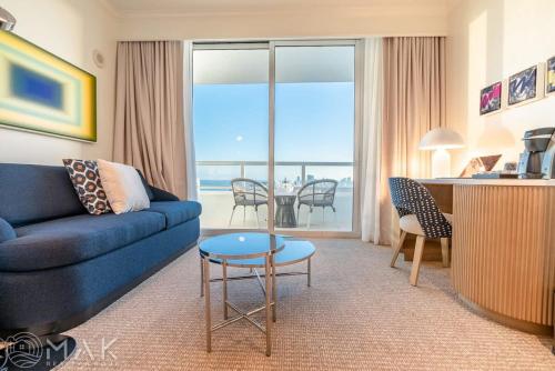 a living room with a blue couch and a table at FontaineBleau Resort High Floor w Ocean Views in Miami Beach