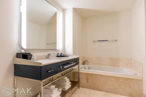 a bathroom with a sink and a tub and a mirror at FontaineBleau Resort High Floor w Ocean Views in Miami Beach