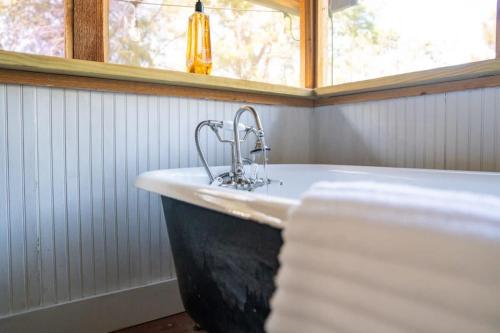 a bathroom with a sink and a tub with a window at A Special Retreat on a Mini-Farm -- in SMTX in San Marcos