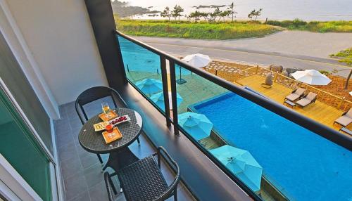 a balcony with a table and a swimming pool at Glories Pension in Buan