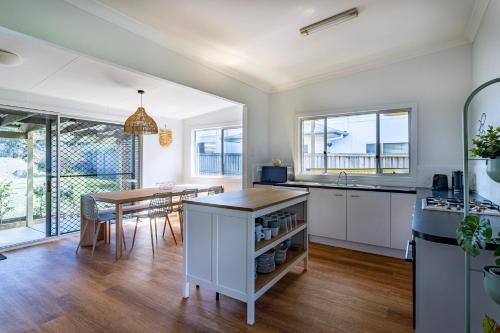 a kitchen and dining room with a table and a dining room at Beachside Cottage in Berrara