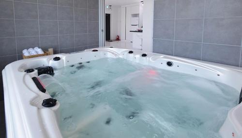 a bath tub filled with blue water in a bathroom at Glories Pension in Buan