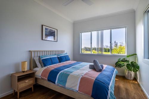 a bedroom with a large bed and a window at Beachside Cottage in Berrara