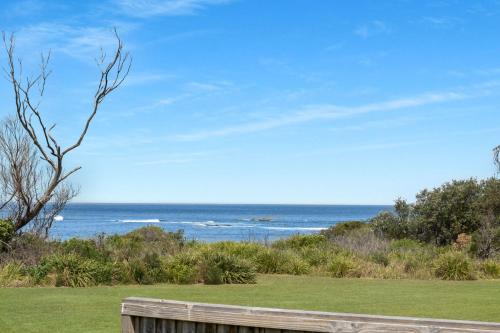 a view of the ocean from a wooden bench at Beachside Cottage in Berrara