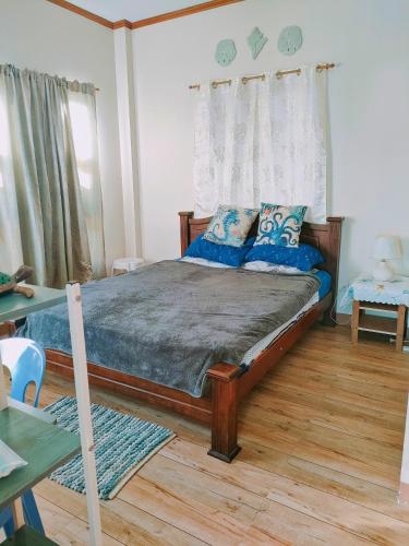 a bedroom with a large bed with blue pillows at Puerto Galera Transient Guest Room in Puerto Galera