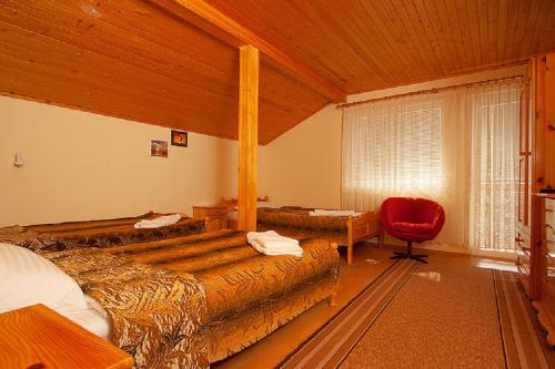バルチクにあるVilla Karinaのベッドルーム1室(ベッド2台、赤い椅子付)