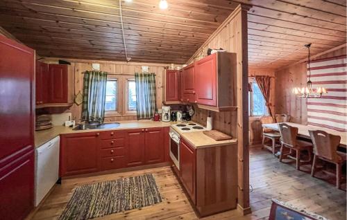 a kitchen with wooden cabinets and a table in a room at Stunning Home In yer With House A Mountain View in Øyer