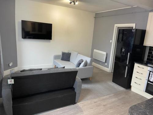 Comfortable flat in Stokes Croft في بريستول: غرفة معيشة مع أريكة وتلفزيون