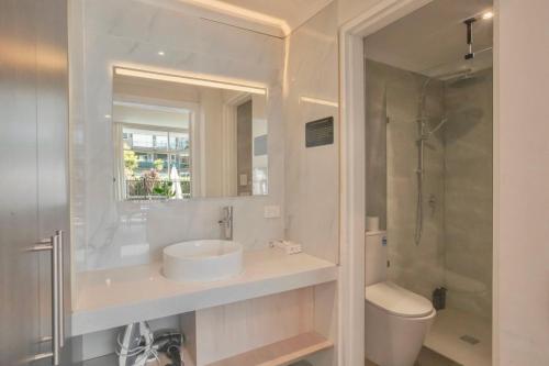 a bathroom with a sink and a toilet and a shower at The Parkmore Hotel in Melbourne