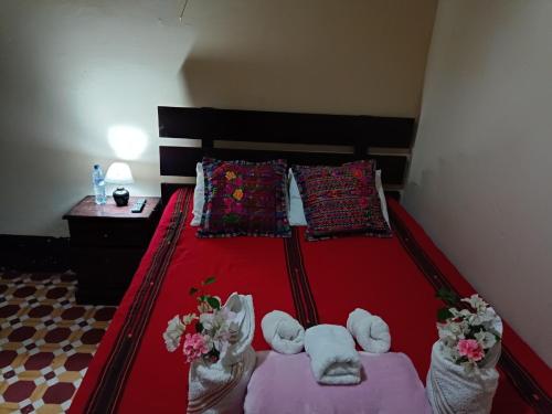 um quarto com uma cama vermelha e 2 almofadas em 59C hostel em Antigua Guatemala