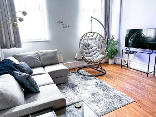 a living room with a couch and a chair at 1 Bedroom Apartment in the City Centre of Nottingham - UNDER NEW MANAGEMENT in Nottingham