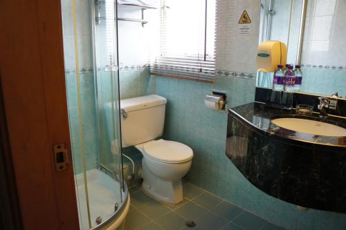 a bathroom with a toilet and a sink and a shower at West Inn in Hong Kong
