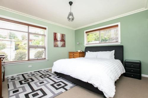 1 dormitorio con 1 cama blanca y 2 ventanas en Comfortable Home with Wifi Parking & Views, en Royal Park
