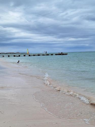 a sandy beach with a pier in the ocean at Apto estudio en Punta Cana, vista a la pisicina in Punta Cana