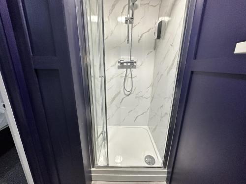 La salle de bains est pourvue d'une douche avec une porte en verre. dans l'établissement Stay Sleep Rest - Gawthorne, à Nottingham