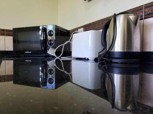 um balcão de cozinha com comodidades para preparar café e um micro-ondas em LE RIC HOUSING LTD em Apia